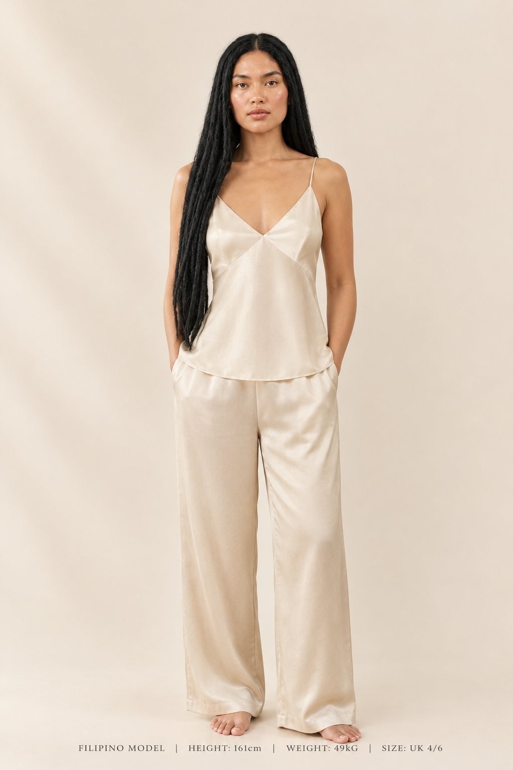 Model wearing a soft champagne silk camisole and wide-leg trousers