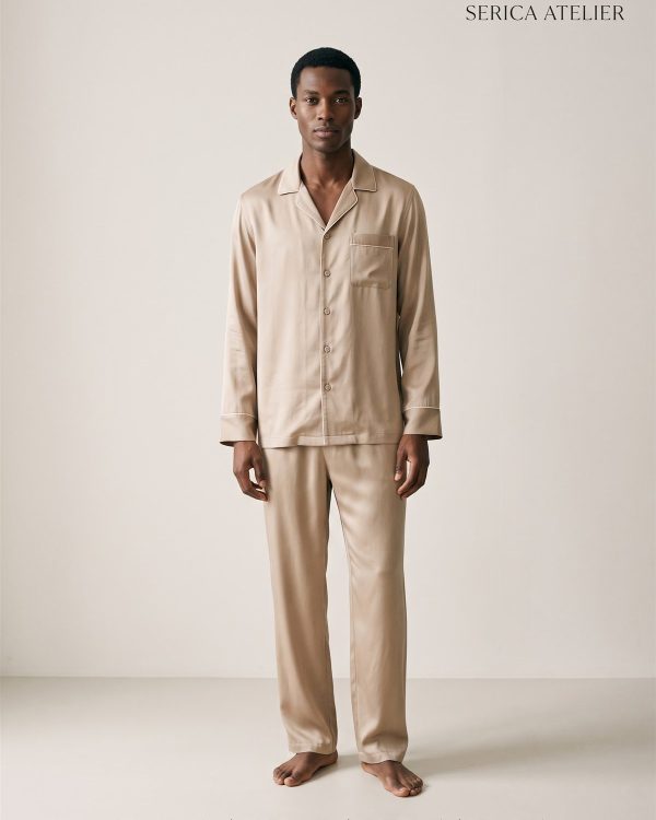 Model wearing a sand-coloured silk notched-lapel pyjama shirt and trousers with ivory piping