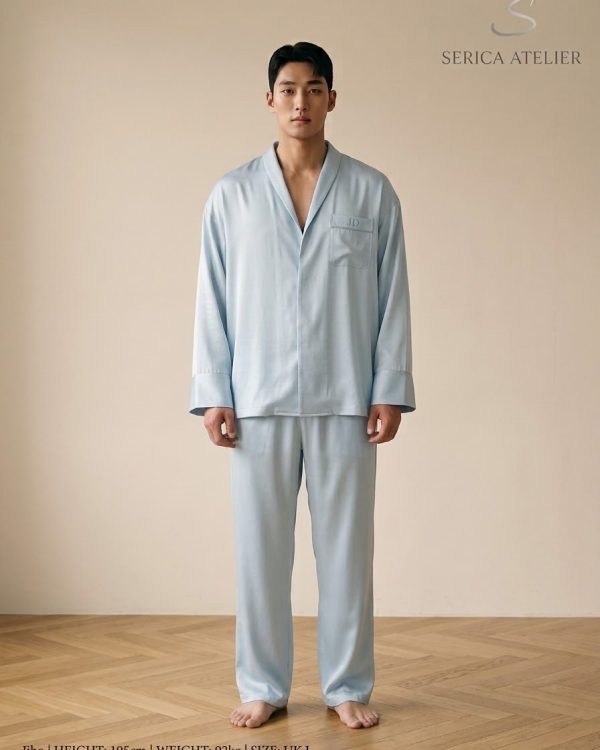 Model in a pale blue silk pyjama set with a monogram on the pocket