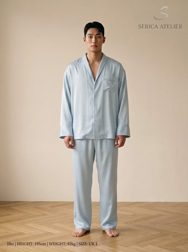 Model in a pale blue silk pyjama set with a monogram on the pocket