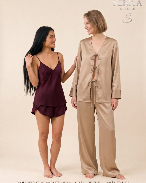 Two models wearing the silk Cami set in burgundy and the Lea tie-front set in a warm sand tone
